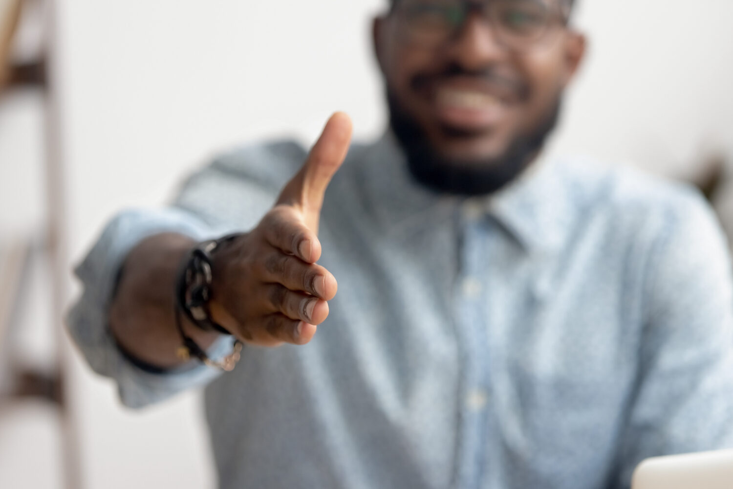 Cheerful male coach poised to shake hands with a new client at the start of their coaching relationship, eager to establish a strong and successful connection