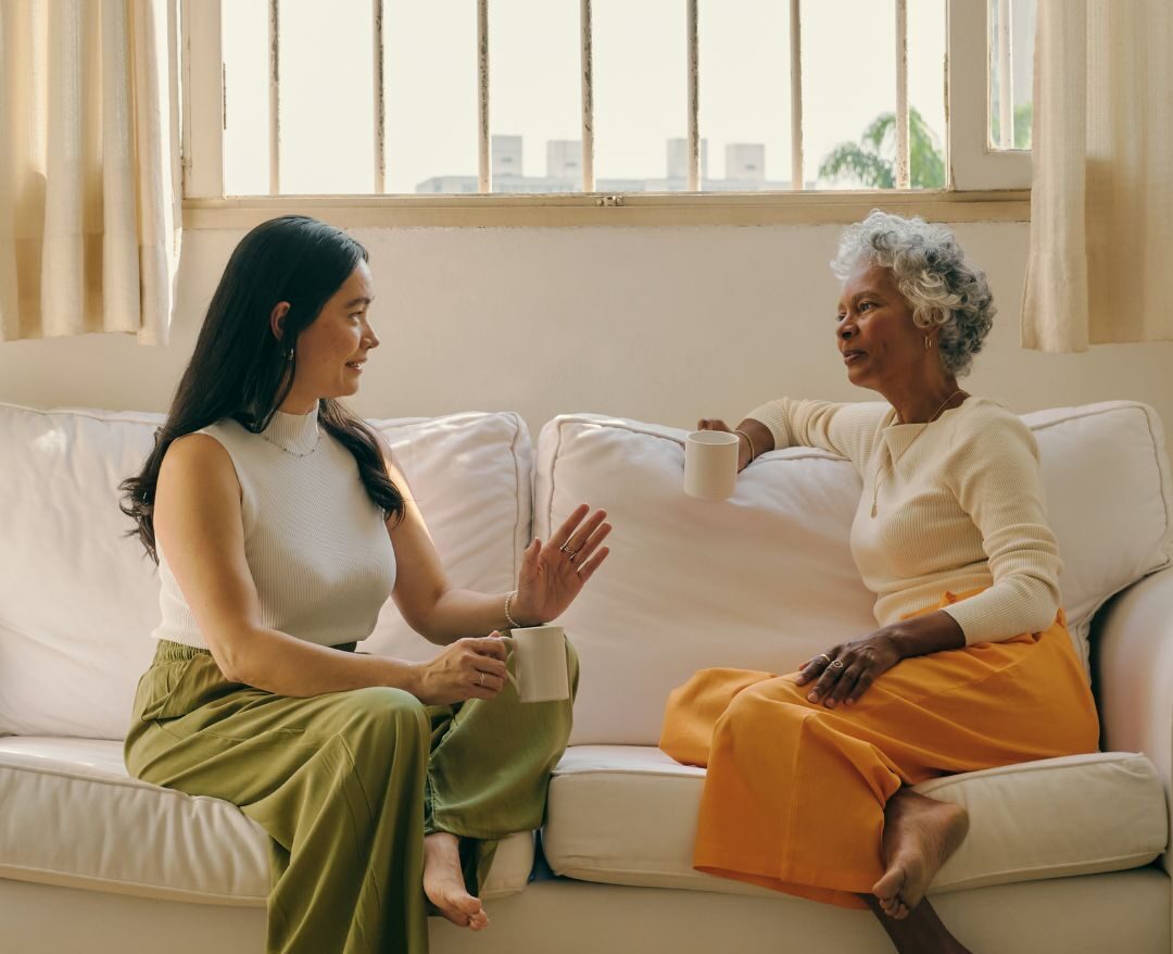 Coach and client exploring somatic sensations sitting on a sofa during a face-to-face coaching session in a relaxed atmosphere